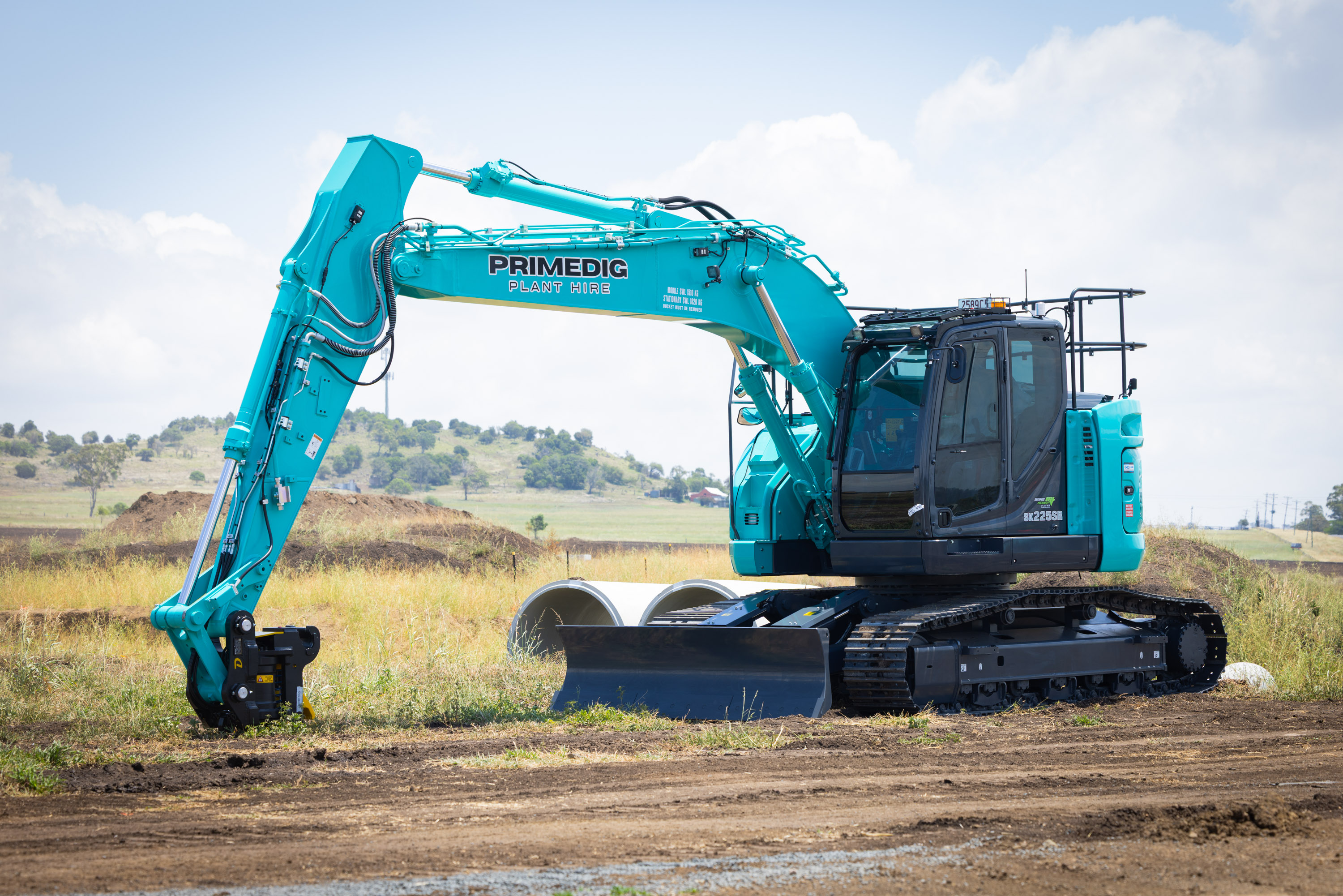Kobelco excavator on a civil site alongside concrete stormwater pipes